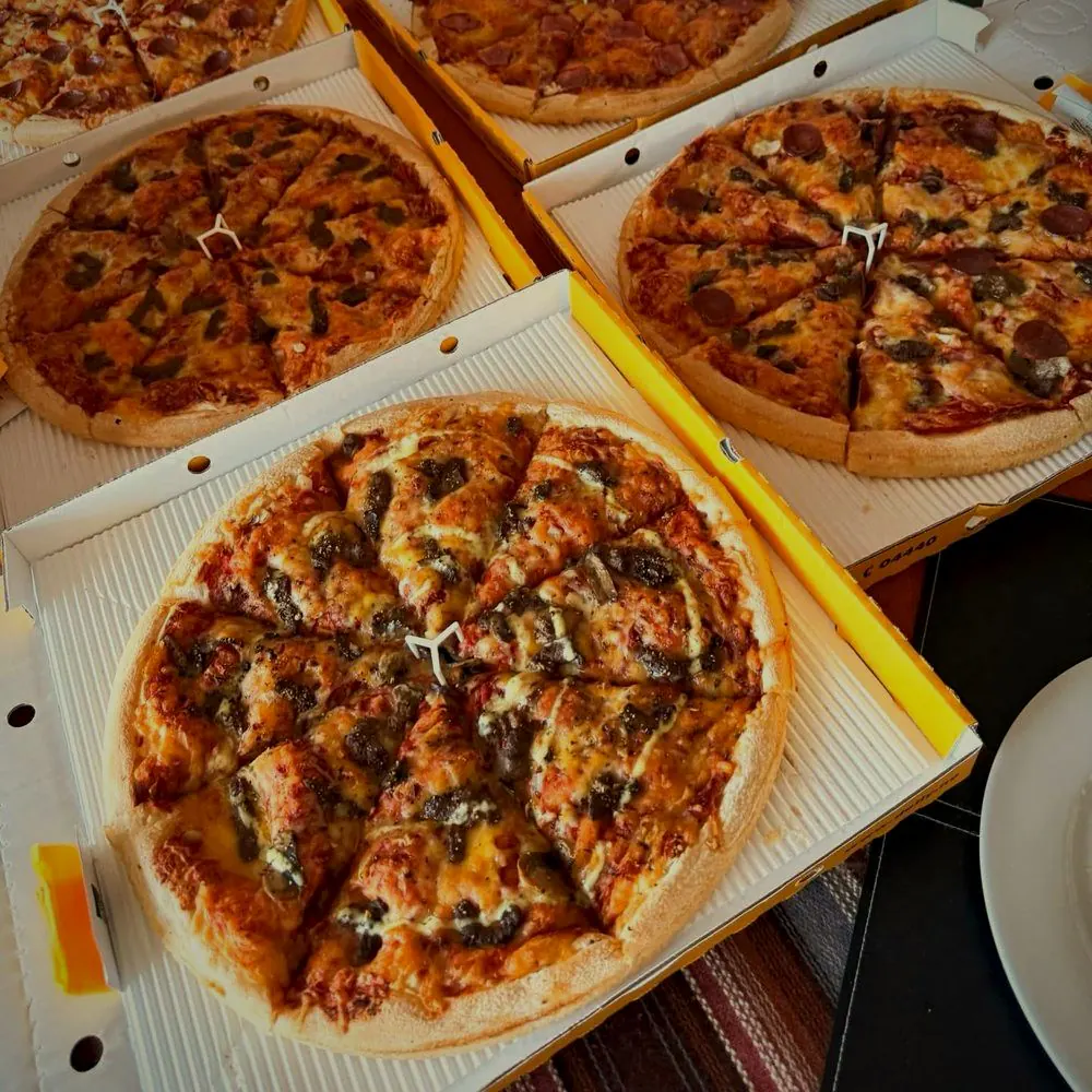 Dolly-pizzaer skåret i stykker i åpne pizzaesker